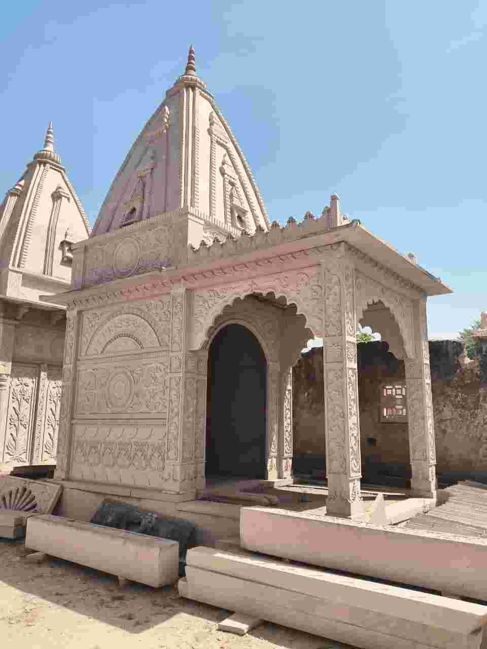 Handcrafted sandstone temple with carved stone pillars