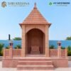 Side view of red stone mandir with traditional stone carving
